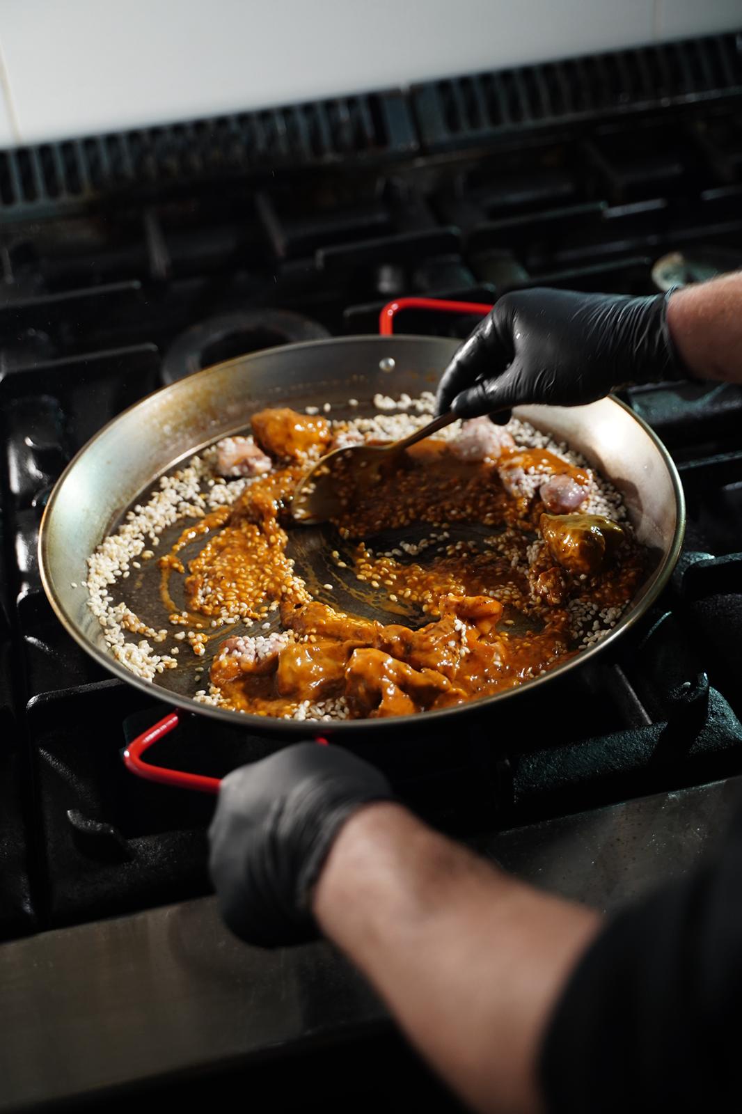 Elaboración de paella valenciana al carbón en la taberna Cavacarbon de Madrid